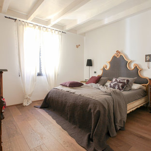 Foto di una camera matrimoniale mediterranea con pareti bianche, parquet scuro e pavimento marrone