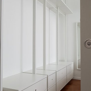 Modelo de dormitorio principal, actual, grande, sin chimenea, con paredes blancas, suelo de baldosas de porcelana y suelo marrón
