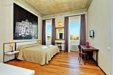ローマにある広いトラディショナルスタイルのおしゃれな主寝室 (緑の壁、無垢フローリング、暖炉なし、茶色い床)
