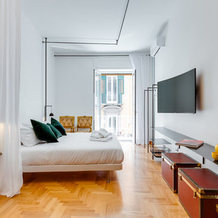 Esempio di una camera da letto design con pareti bianche, pavimento in legno massello medio e pavimento marrone