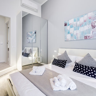 Esempio di una camera da letto contemporanea con pareti bianche, parquet chiaro e pavimento beige