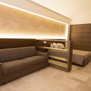 Diseño de dormitorio tipo loft, campestre, de tamaño medio, con paredes beige, suelo de piedra caliza y suelo beige
