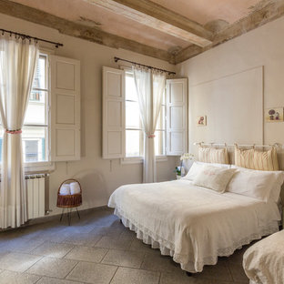 Immagine di una camera da letto mediterranea con pareti bianche e pavimento grigio