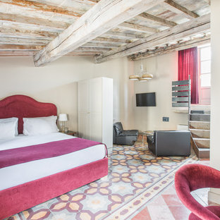Esempio di una camera da letto mediterranea con pareti beige e pavimento multicolore