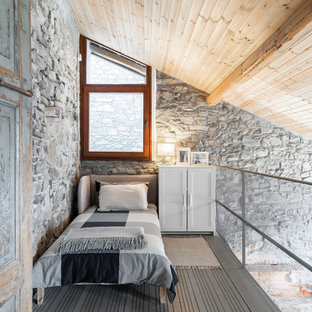 Immagine di una camera da letto stile loft mediterranea con pareti grigie, nessun camino e pavimento grigio