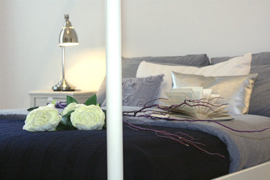 Esempio di una camera matrimoniale minimalista con pareti beige e parquet chiaro