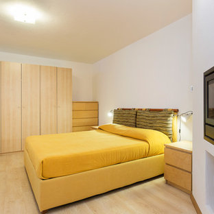 Foto de habitación de invitados rústica, pequeña, con paredes blancas, suelo de madera en tonos medios, chimenea lineal, marco de chimenea de metal y suelo beige
