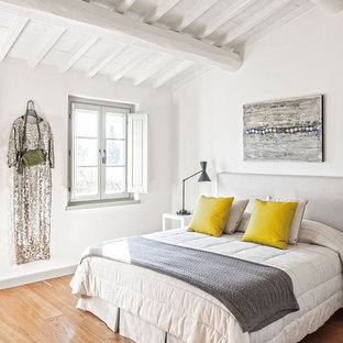 Ispirazione per una camera da letto mediterranea con pareti bianche e pavimento in legno massello medio