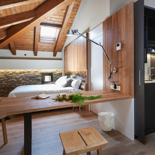 Imagen de dormitorio rústico, sin chimenea, con paredes blancas, suelo de madera en tonos medios y suelo marrón
