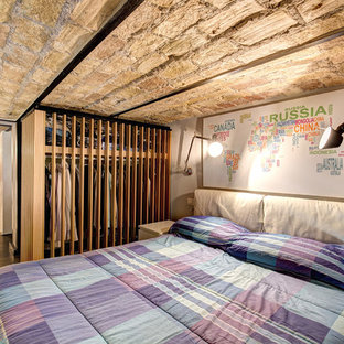 Inspiration for a mid-sized industrial master bedroom in Rome with beige walls, medium hardwood floors and brown floor.