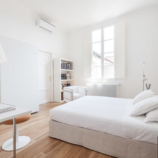 Ispirazione per una camera da letto design con pareti bianche, pavimento in legno massello medio e pavimento marrone