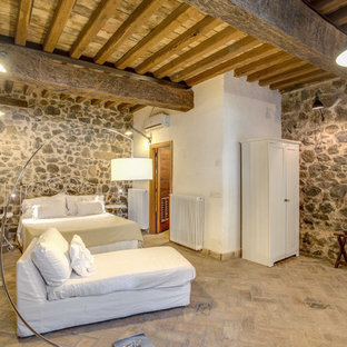 Modelo de dormitorio principal, de estilo de casa de campo, extra grande, con suelo de ladrillo