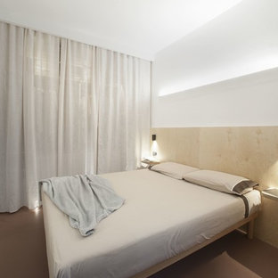 Ejemplo de dormitorio principal, moderno, pequeño, con paredes blancas, suelo de cemento y suelo rojo