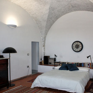 Foto de dormitorio tipo loft, actual, de tamaño medio, con paredes blancas, suelo de baldosas de terracota y suelo rojo