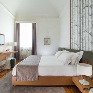 Immagine di una camera matrimoniale design con parquet scuro, pareti bianche, nessun camino e pavimento marrone