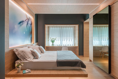 Ispirazione per una camera matrimoniale design di medie dimensioni con pareti marroni, parquet chiaro e pavimento marrone