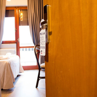 Modelo de dormitorio principal, actual, de tamaño medio, con suelo laminado y suelo beige