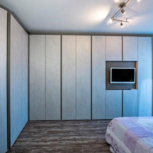Imagen de dormitorio principal, actual, de tamaño medio, con paredes blancas, suelo de baldosas de porcelana y suelo marrón
