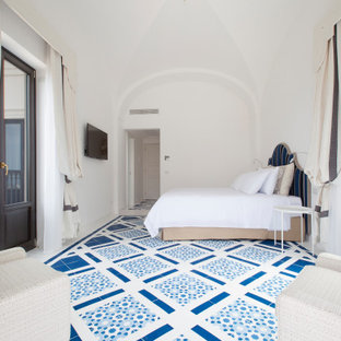 Immagine di una camera da letto mediterranea con pareti bianche e pavimento blu