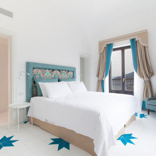 Foto di una camera da letto mediterranea con pareti bianche e pavimento multicolore