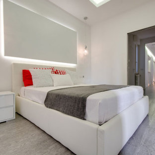 Foto di un'ampia camera matrimoniale moderna con pareti bianche, parquet chiaro, camino sospeso, cornice del camino in intonaco, pavimento beige e soffitto ribassato