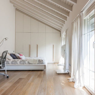 Immagine di un'ampia camera matrimoniale country con pareti bianche, parquet chiaro e pavimento beige