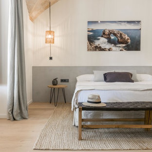 Immagine di una camera da letto mediterranea con pareti bianche, parquet chiaro e pavimento beige