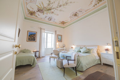 Esempio di un'ampia camera degli ospiti chic con pareti beige e pavimento in legno massello medio