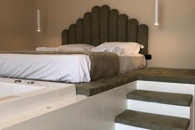 Esempio di una grande camera da letto stile loft mediterranea con pareti beige, pavimento in legno verniciato e pavimento bianco