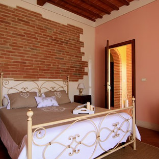 Mid-sized country guest bedroom in Other with pink walls, terra-cotta floors and brown floor.