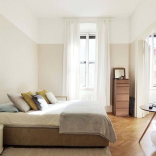 Idées déco pour une chambre parentale contemporaine de taille moyenne avec un mur gris, un sol en bois brun et un sol jaune.