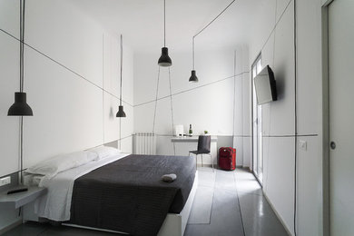 ローマにある中くらいなコンテンポラリースタイルのおしゃれな主寝室 (白い壁、コンクリートの床、グレーの床)