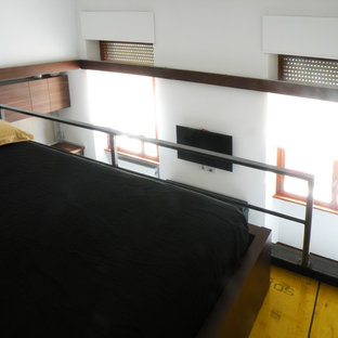 Imagen de dormitorio tipo loft, urbano, pequeño, con paredes blancas, suelo de madera pintada y suelo amarillo