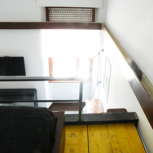 Imagen de dormitorio tipo loft, industrial, pequeño, con paredes blancas, suelo de madera pintada y suelo amarillo