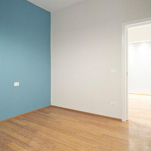 Ejemplo de dormitorio principal, contemporáneo, pequeño, con suelo de bambú, suelo marrón y paredes azules