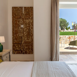 Imagen de dormitorio principal, mediterráneo, pequeño, con paredes blancas y suelo de piedra caliza