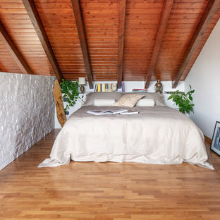 Ispirazione per una grande camera da letto stile loft nordica con pareti bianche, parquet chiaro e pavimento beige