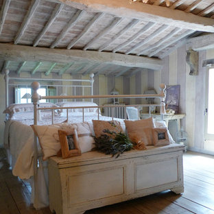 Imagen de dormitorio tipo loft, campestre, grande, con suelo de baldosas de terracota, estufa de leña y marco de chimenea de metal
