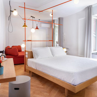 Immagine di una camera da letto minimal con pareti grigie, pavimento in legno massello medio e pavimento marrone