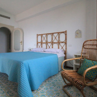 Ejemplo de habitación de invitados exótica, pequeña, con paredes blancas, suelo de baldosas de cerámica y suelo multicolor
