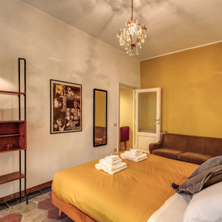 Foto de dormitorio principal, vintage, de tamaño medio, con paredes amarillas, suelo de cemento y suelo multicolor