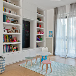 Immagine di una cameretta per bambini minimal con pareti bianche, parquet chiaro e pavimento beige