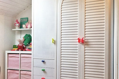 Esempio di una cameretta per bambini da 4 a 10 anni boho chic con pareti bianche, pavimento in legno massello medio e pavimento marrone