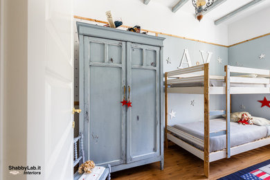 Immagine di una piccola cameretta per bambini da 4 a 10 anni stile shabby con pareti blu