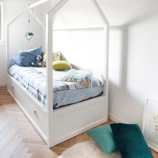 Idee per una cameretta per bambini da 4 a 10 anni scandinava con pareti bianche, parquet chiaro e pavimento beige