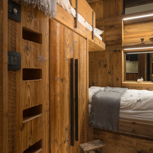 Idee per una cameretta da letto stile rurale con pareti marroni, pavimento in legno massello medio, pavimento marrone e pareti in legno