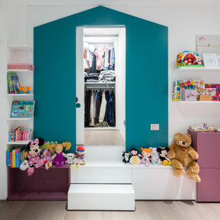 Foto di una cameretta per bambini minimal con pareti bianche, parquet chiaro e pavimento beige