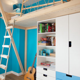 Idee per una cameretta per bambini minimal di medie dimensioni con pareti blu, pavimento in legno massello medio e pavimento beige