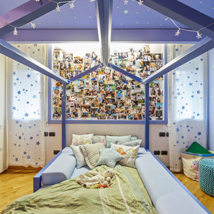 Idee per una cameretta per bambini da 4 a 10 anni design con pareti blu, pavimento in legno massello medio e pavimento marrone