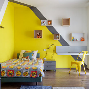 Ispirazione per una cameretta per bambini da 4 a 10 anni design di medie dimensioni con pareti multicolore, pavimento in legno massello medio e pavimento marrone